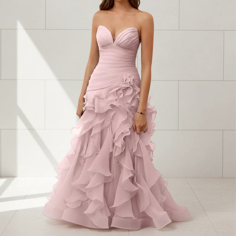 Pink strapless gown with ruffled layers on a white background
