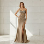 Woman wearing a beige evening gown with intricate detailing on a white background