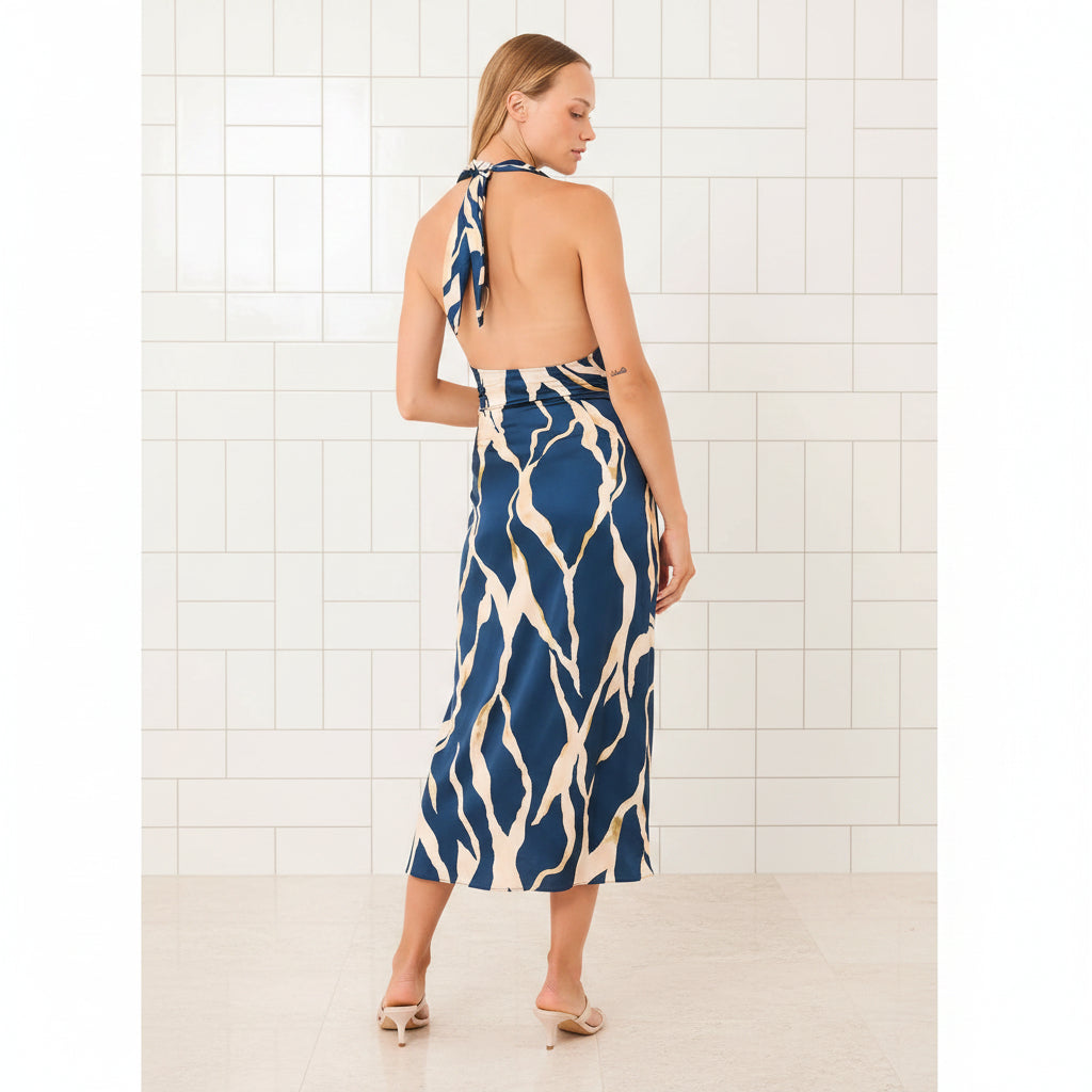 Woman wearing a blue and white patterned dress with a halter neck design.