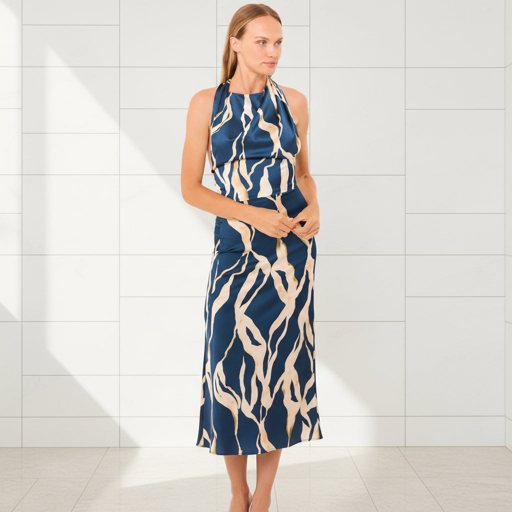 Woman wearing a blue and beige patterned dress on a white background