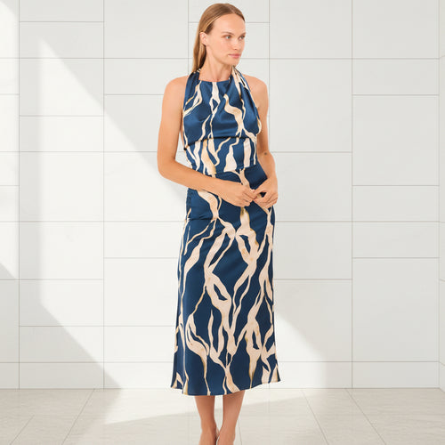 Woman wearing a blue and beige patterned dress on a white background
