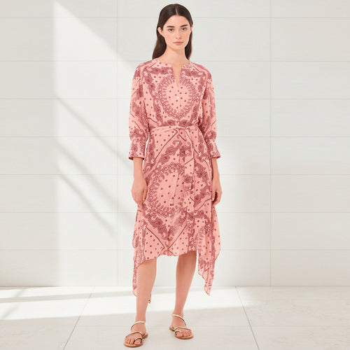 Woman wearing a pink patterned dress on a white background