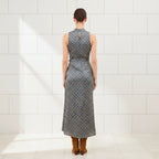 Woman wearing a sleeveless patterned dress on a white background