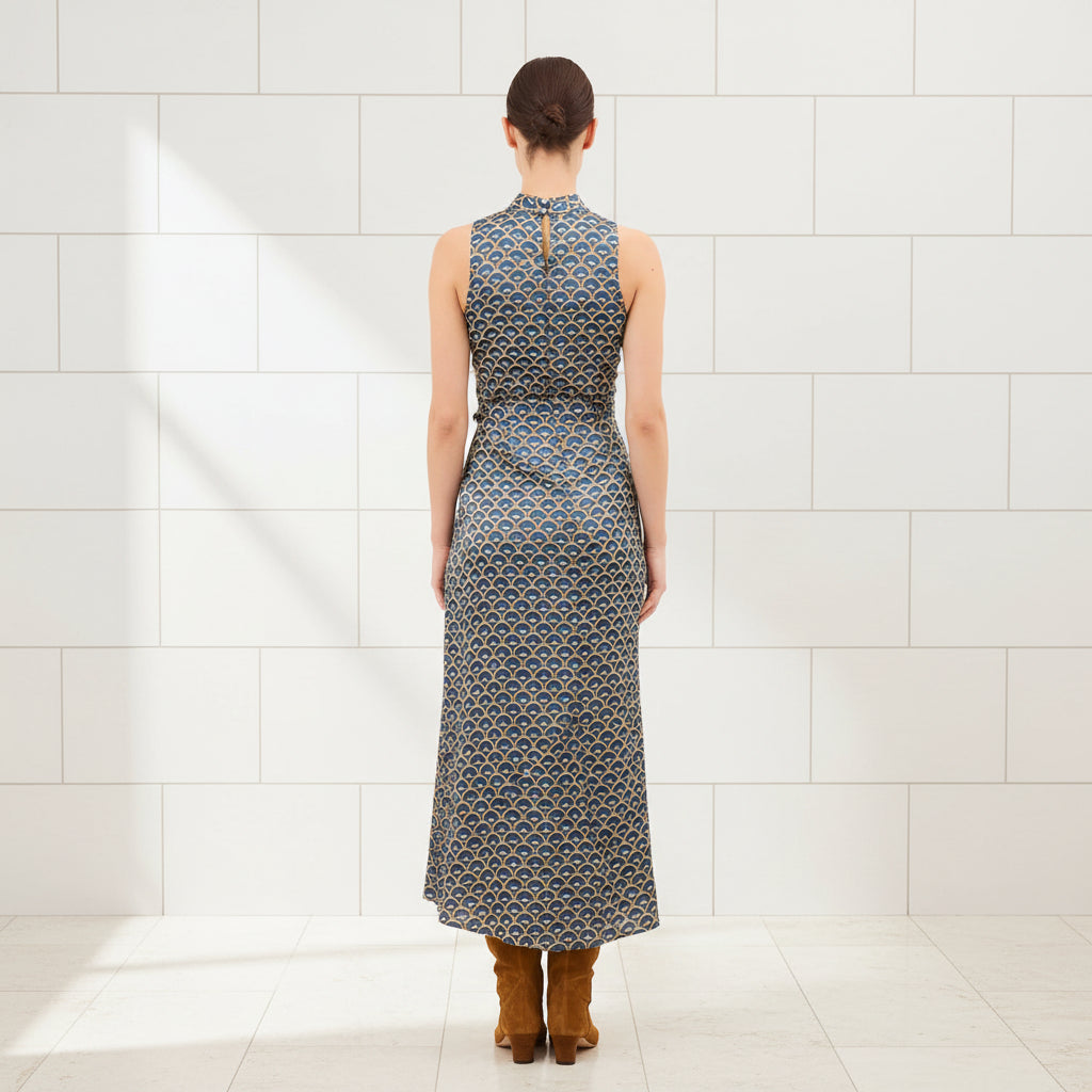 Woman wearing a sleeveless patterned dress on a white background