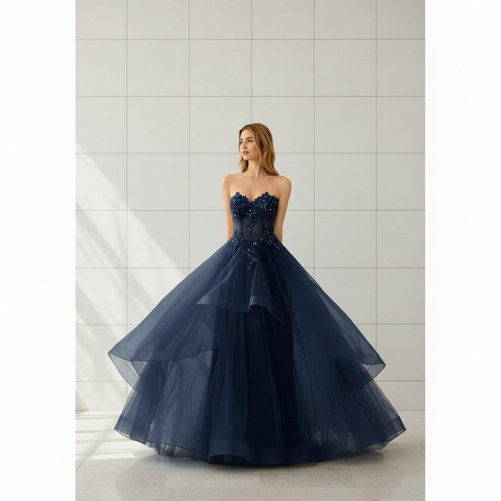Navy blue strapless gown with intricate detailing on a white background