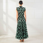Woman wearing a green and black patterned dress on a white background