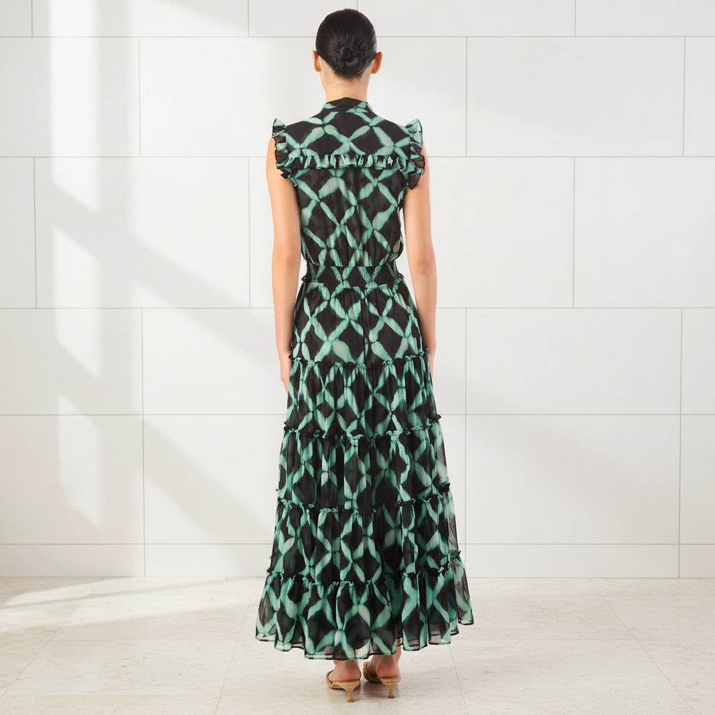 Woman wearing a green and black patterned dress on a white background