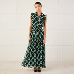 Woman wearing a green and black patterned dress with ruffled shoulders on a white background