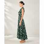 Woman wearing a green and black patterned dress on a white background