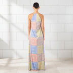 Woman wearing a colorful patterned halter neck dress on a white background
