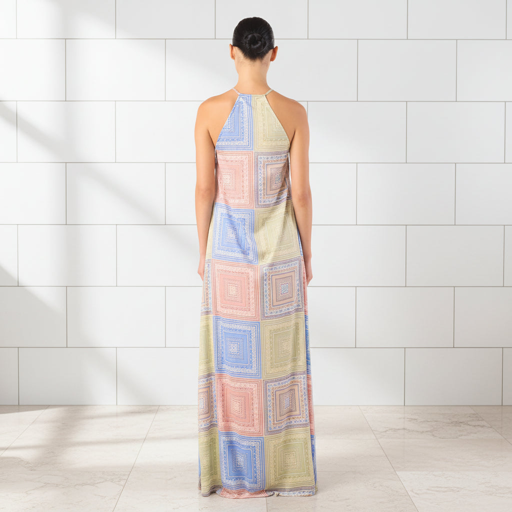 Woman wearing a colorful patterned halter neck dress on a white background
