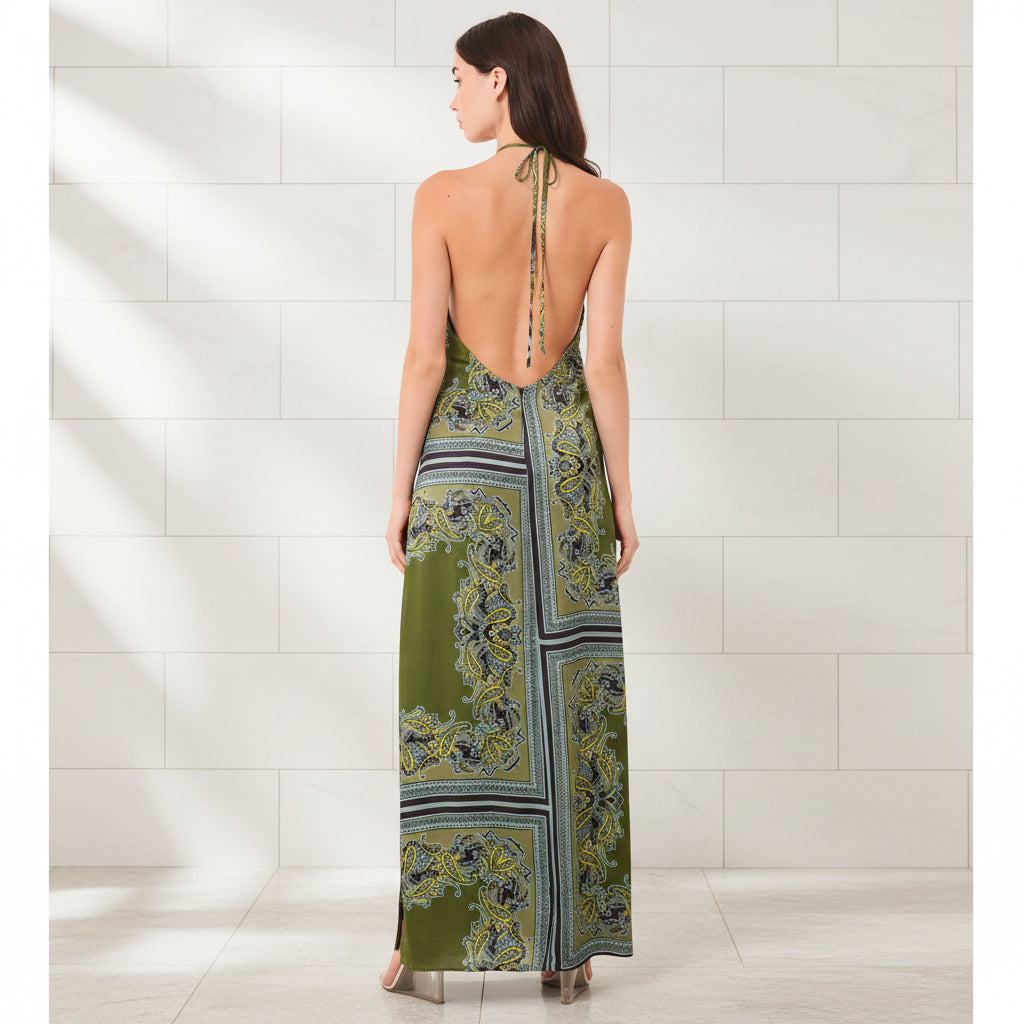 Woman wearing a green patterned dress with open back on a white background