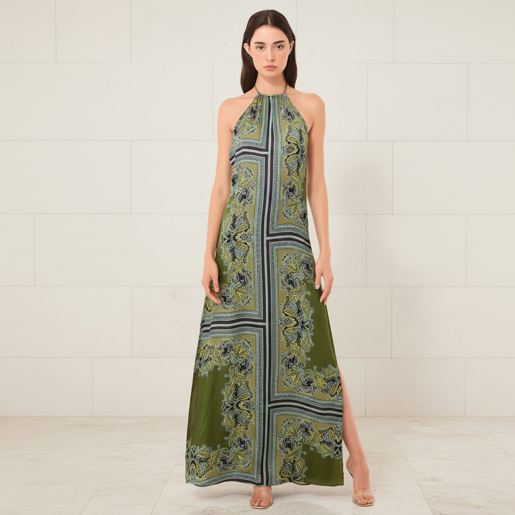 Woman wearing a green patterned halter neck dress on a beige background