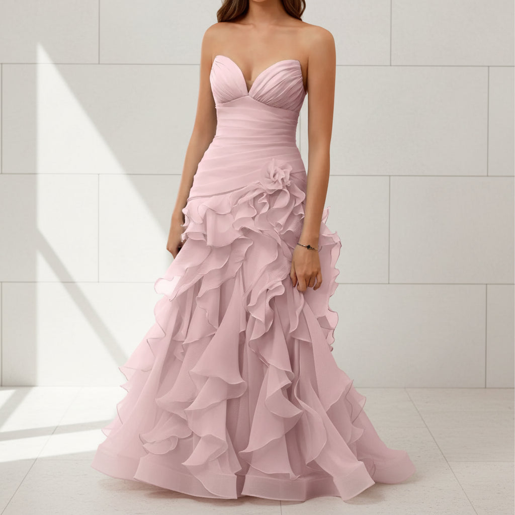 Pink strapless gown with ruffled layers on a white background