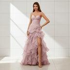 Pink strapless gown with ruffled layers and a high slit on a white background