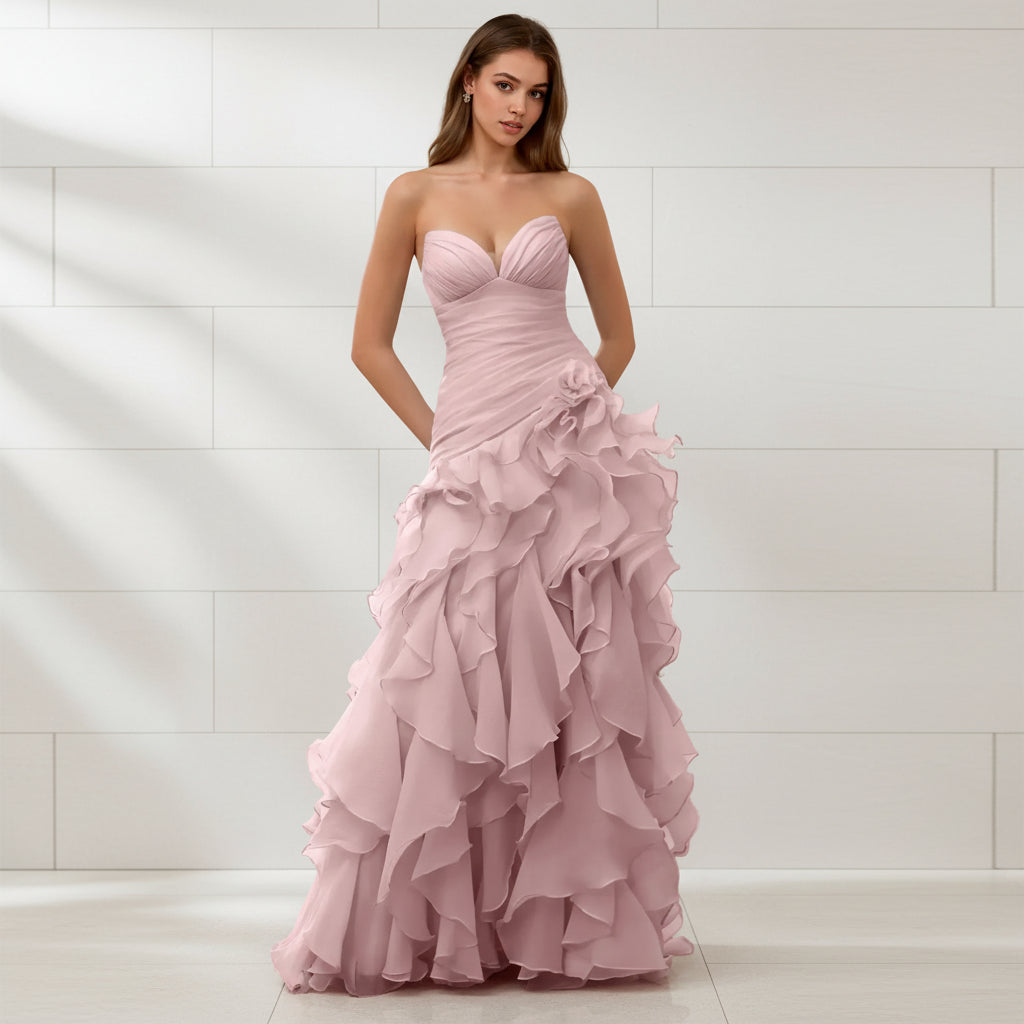 Pink strapless gown with ruffled layers on a white background