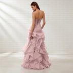 Pink strapless gown with ruffled layers on a white background