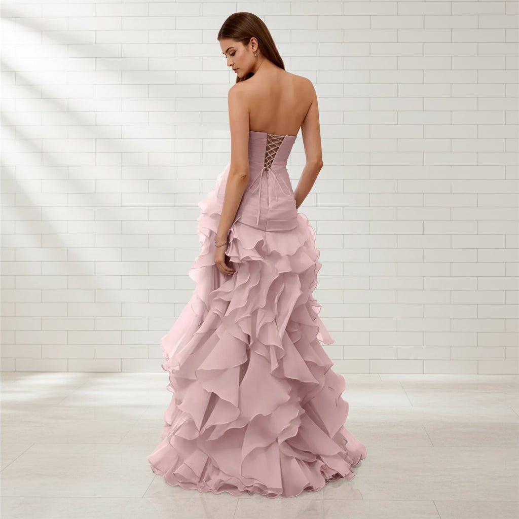 Pink strapless gown with ruffled layers on a white background